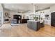 Open-concept kitchen flowing into the living room, featuring a gray island and modern appliances at 2932 Heron Lakes Pkwy, Berthoud, CO 80513