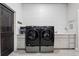 Modern laundry room featuring front-loading washer and dryer on pedestals and white shiplap at 2932 Heron Lakes Pkwy, Berthoud, CO 80513