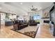 Open-concept living room with hardwood floors, fireplace, and views of the kitchen and outdoor scenery at 2932 Heron Lakes Pkwy, Berthoud, CO 80513