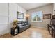 Bright living room featuring hardwood floors, a comfortable leather sofa, and a decorative accent wall at 2932 Heron Lakes Pkwy, Berthoud, CO 80513