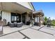 Covered patio features a hot tub, seating, ceiling fan, and stone accents at 2932 Heron Lakes Pkwy, Berthoud, CO 80513