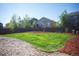 Spacious back yard featuring well-maintained lawn, mulch beds, and a wood fence for privacy at 7812 Blue Water Ln, Castle Rock, CO 80108