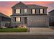 Charming two-story home featuring a covered porch, shutters, and a two-car garage during sunset at 7812 Blue Water Ln, Castle Rock, CO 80108