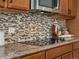 Close up of the kitchen area featuring mosaic backsplash, granite countertops, and stainless appliances at 7812 Blue Water Ln, Castle Rock, CO 80108