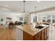 Open-concept kitchen boasts an island, stylish pendant lighting, and flows into the living and dining areas at 7812 Blue Water Ln, Castle Rock, CO 80108