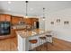 Bright kitchen with wooden cabinets, modern stainless steel appliances, granite counters, and three stools at the island at 7812 Blue Water Ln, Castle Rock, CO 80108