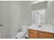 Cozy half-bathroom has wood-like flooring, white toilet, and a wooden vanity with sink at 9690 Lansing Cir, Commerce City, CO 80022