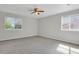 Spacious bedroom with large windows, neutral carpeting, and ceiling fan for comfort at 9690 Lansing Cir, Commerce City, CO 80022