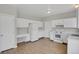 Well-lit kitchen featuring white cabinets, a cozy desk area, and new vinyl floors at 9690 Lansing Cir, Commerce City, CO 80022