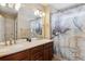 Bathroom featuring double sinks, a large mirror, and a shower-tub combination with a stylish curtain at 25850 E 3Rd Ave, Aurora, CO 80018