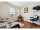Well-lit bedroom with hardwood floors, a window, and a dedicated workspace with a desk and chair at 25850 E 3Rd Ave, Aurora, CO 80018