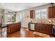 Open kitchen featuring an island with granite countertops, wood cabinets, and a stainless steel dishwasher at 25850 E 3Rd Ave, Aurora, CO 80018