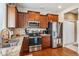 Functional kitchen with stainless steel appliances, wooden cabinets, and ample counter space at 25850 E 3Rd Ave, Aurora, CO 80018