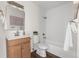 Bathroom featuring white tiled walls, wooden vanity, and a shower-tub combo at 5991 W 68Th Ave, Arvada, CO 80003