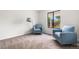 Bright, spacious bedroom featuring a large window and plush blue armchairs at 5991 W 68Th Ave, Arvada, CO 80003
