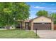 Welcoming home featuring a well-maintained lawn, mature trees, and an attached two-car garage at 5991 W 68Th Ave, Arvada, CO 80003