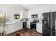 Modern kitchen featuring white cabinetry, sleek black appliances, and beautiful hardwood flooring at 5991 W 68Th Ave, Arvada, CO 80003