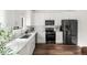 Well-lit kitchen with stainless steel appliances, white cabinets, quartz countertops, and modern backsplash at 5991 W 68Th Ave, Arvada, CO 80003