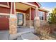 Charming covered front porch with decorative brick pillars and a welcoming entrance at 1038 Petras St, Erie, CO 80516