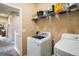 Convenient laundry room with modern washer, dryer, and shelving for ample storage at 1038 Petras St, Erie, CO 80516