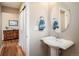 This charming powder room features a pedestal sink and a stylish round mirror at 1038 Petras St, Erie, CO 80516