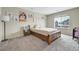 Cozy bedroom features neutral paint, a modern light fixture and a view of the neighborhood at 4733 S Wenatchee Cir, Aurora, CO 80015