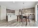 Eat-in kitchen with a marble dining table, modern lighting, stainless appliances and wood-look floors at 4733 S Wenatchee Cir, Aurora, CO 80015