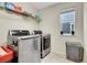 Bright laundry room with stainless steel washer and dryer, ample storage, and natural light at 4733 S Wenatchee Cir, Aurora, CO 80015