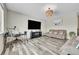 Open-concept living room with couches, large screen TV, and hardwood-style flooring at 4733 S Wenatchee Cir, Aurora, CO 80015