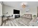 Neutral living room with wood floors, brown couches and a large TV at 4733 S Wenatchee Cir, Aurora, CO 80015