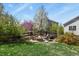 Landscaped backyard features a stone fire pit and mature trees and shrubs at 1794 Wright Dr, Erie, CO 80516