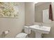 Elegant powder room features a pedestal sink, a decorative mirror, and neutral paint at 1794 Wright Dr, Erie, CO 80516