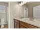 Bathroom with double sinks, vanity with dark cabinets, and neutral countertops at 1794 Wright Dr, Erie, CO 80516
