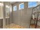Large glass shower with stone tile, gray subway tiles, and bright, natural light from multiple windows at 1794 Wright Dr, Erie, CO 80516