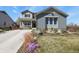 Charming two-story home featuring a welcoming front porch and beautifully landscaped front yard with flowers at 1794 Wright Dr, Erie, CO 80516