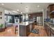 Spacious kitchen features granite counters, stainless appliances, and open access to the living room and fireplace at 1794 Wright Dr, Erie, CO 80516
