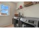 Laundry room with stainless steel washer and dryer and shelving for convenient storage at 1794 Wright Dr, Erie, CO 80516