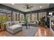 Bright living room with a large sectional sofa, a ceiling fan, and many windows with outside views at 1794 Wright Dr, Erie, CO 80516