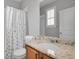 Bathroom featuring a vanity with a granite countertop, single sink, mirror, and a shower with floral curtains at 8977 E Otero Pl, Centennial, CO 80112