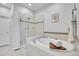 Bright bathroom featuring a soaking tub with tile surround and glass-enclosed shower at 8977 E Otero Pl, Centennial, CO 80112