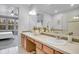 Bathroom featuring double sinks, vanity, and a mirror reflecting an adjacent bedroom with large window at 8977 E Otero Pl, Centennial, CO 80112