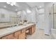 Bright bathroom featuring double sinks, a vanity area and a glass shower with light tile at 8977 E Otero Pl, Centennial, CO 80112