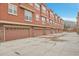 Row of garages with brick and stucco, each with carriage doors and room for parking at 8977 E Otero Pl, Centennial, CO 80112