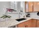 Close-up of a modern kitchen sink, granite countertops, and white subway tile backsplash at 8977 E Otero Pl, Centennial, CO 80112