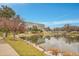 Community pond featuring a rock waterfall, manicured landscaping, and mirrored building reflection at 8977 E Otero Pl, Centennial, CO 80112