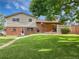 Manicured backyard with brick accents, lawn, and partial shade from a large tree under a bright sky at 10371 Monterey Cir, Northglenn, CO 80260