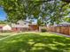 Backyard featuring healthy green grass, mature trees, and privacy fencing, creating a serene outdoor space at 10371 Monterey Cir, Northglenn, CO 80260