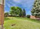 Expansive green backyard with mature trees, privacy fence, shed, and fire pit, perfect for outdoor entertaining at 10371 Monterey Cir, Northglenn, CO 80260