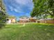 A spacious green backyard with trees under a blue sky, offering ample space for outdoor activities at 10371 Monterey Cir, Northglenn, CO 80260