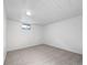 Spacious carpeted basement with white walls and ceiling, illuminated by an overhead light and a window at 10371 Monterey Cir, Northglenn, CO 80260